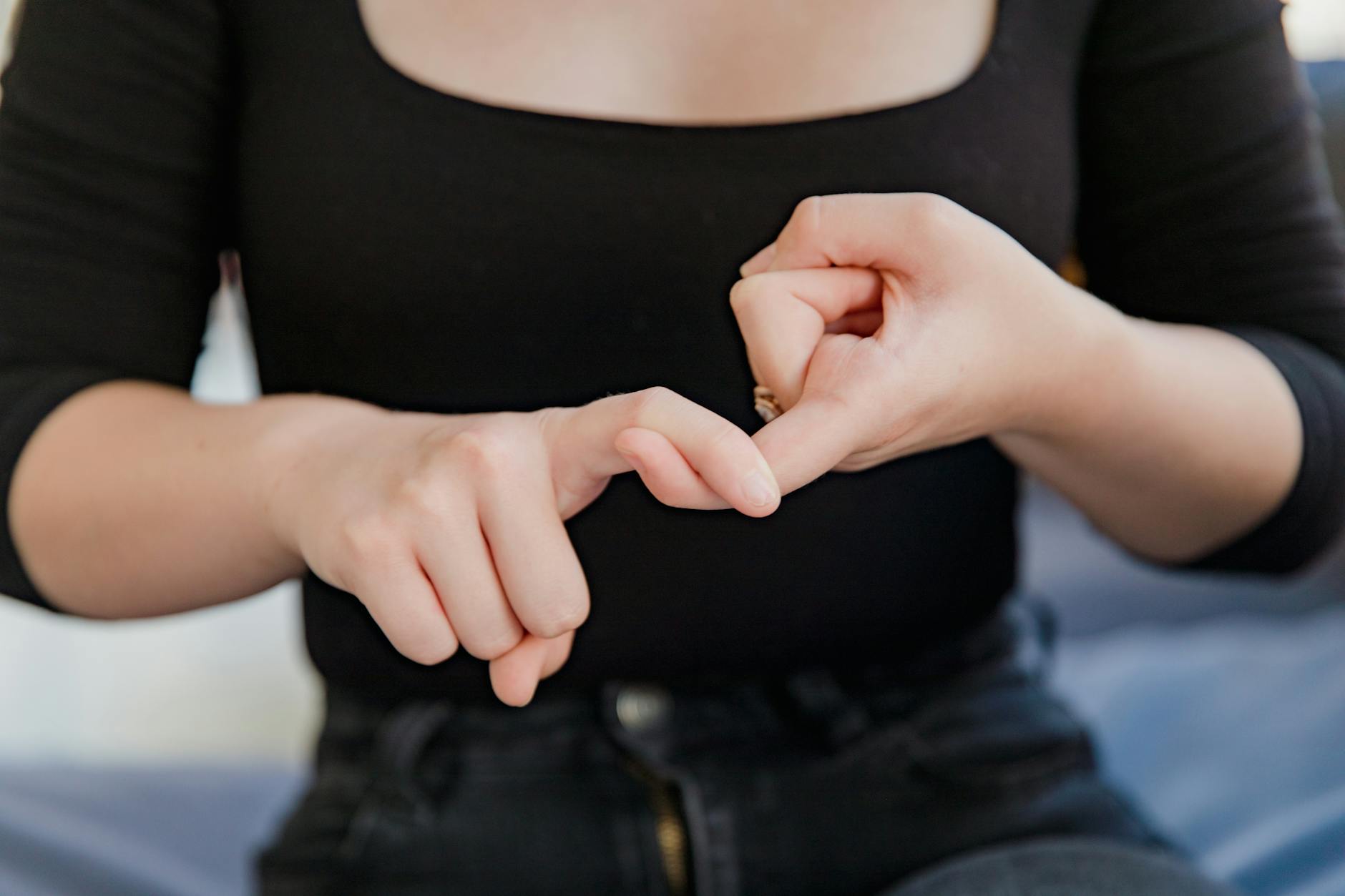 midsection of woman showing sign language